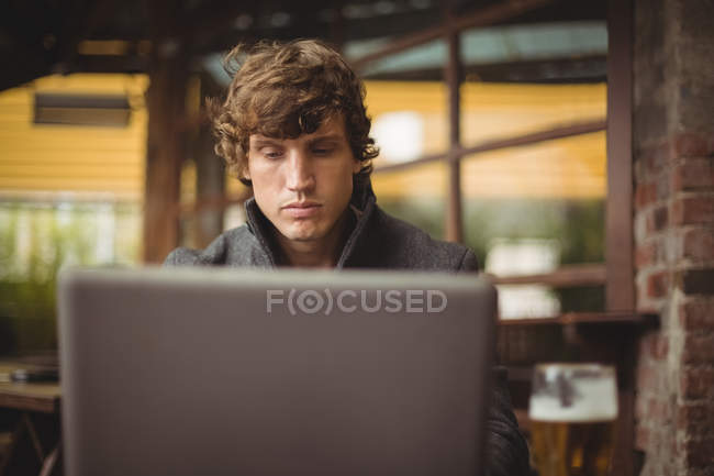 Hombre usando el ordenador portátil en el bar - foto de stock