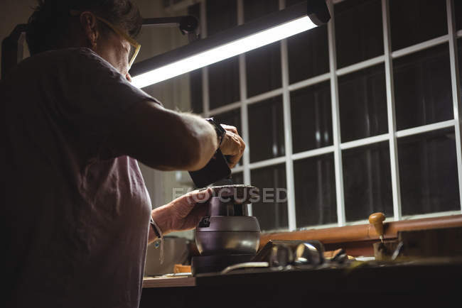 Nahaufnahme einer Handwerkerin, die in einer Werkstatt arbeitet — Stockfoto