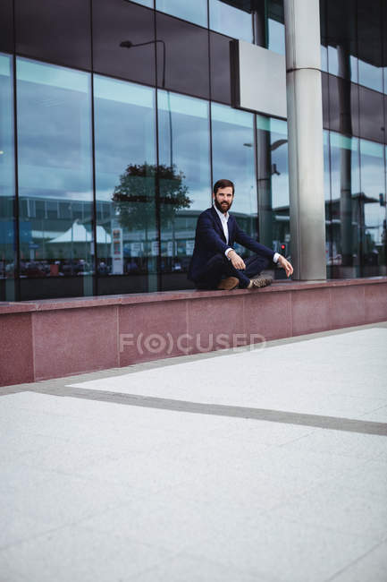 Empresário praticando ioga fora do prédio de escritórios — Fotografia de Stock