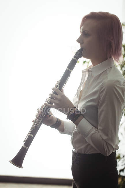 Belle femme jouant une clarinette à l'école de musique — Photo de stock