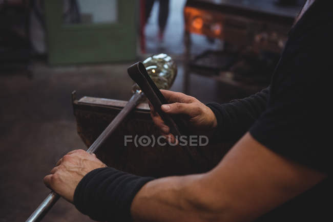 Cropped image of Glassblower shaping molten glass at glassblowing factory — Stock Photo