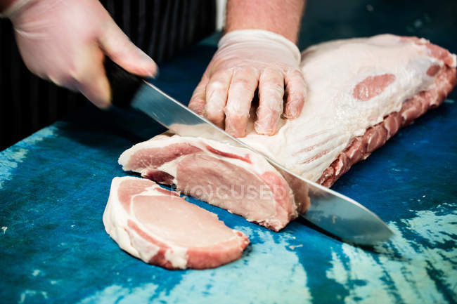 Fleischerhände schneiden Fleisch in Metzgerei — Stockfoto