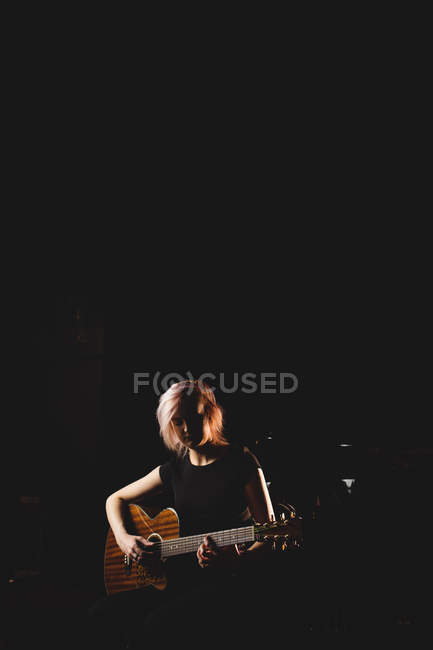 Estudante feminina tocando guitarra em um estúdio — Fotografia de Stock