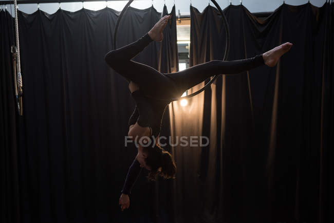 Jeune femme faisant de la gymnastique sur cerceau dans un studio de fitness — Photo de stock