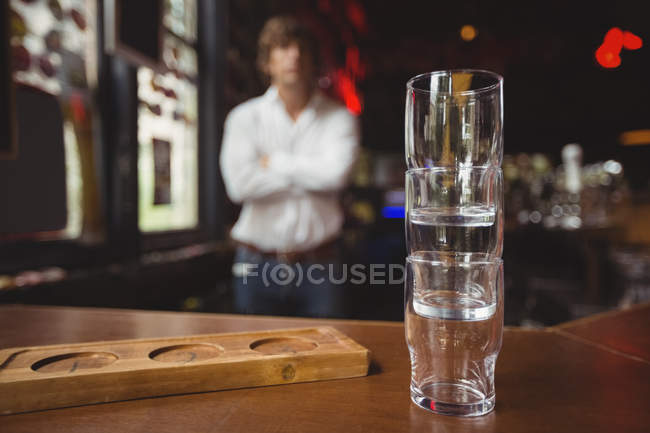 Empilhadeira vazia de copo de cerveja e bandeja no balcão do bar no bar — Fotografia de Stock