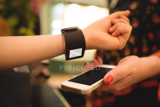 Gros plan des mains féminines effectuant le paiement via smartwatch — Photo de stock