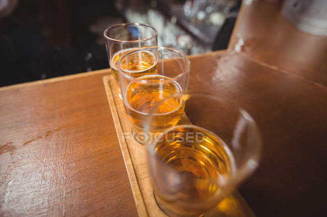 Primo piano dei bicchieri di birra sul bancone del bar — Foto stock