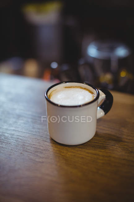 Xícara de cappuccino na mesa na loja de bicicletas — Fotografia de Stock
