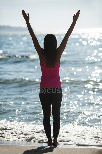 Rear view of woman practicing yoga on beach on sunny day — Stock Photo