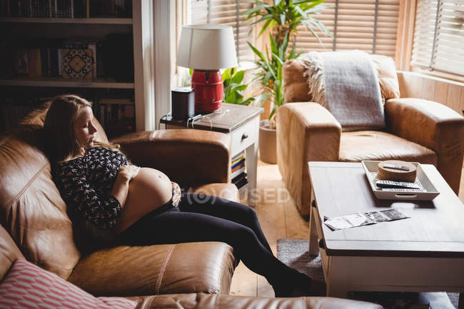 Blick aus der Vogelperspektive: Schwangere entspannt sich im heimischen Wohnzimmer — Stockfoto