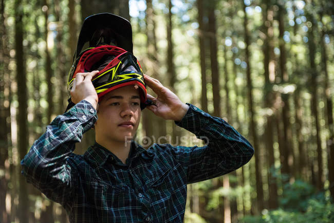 Adolescent sportif portant un casque de vélo dans la campagne — Photo de stock