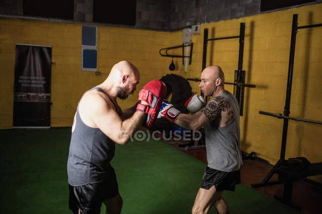 Seitenansicht zweier thailändischer Boxer, die im Fitnessstudio boxen — Stockfoto