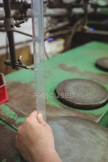 Рука скляного змішувача, що вивчає скляний посуд на заводі — стокове фото