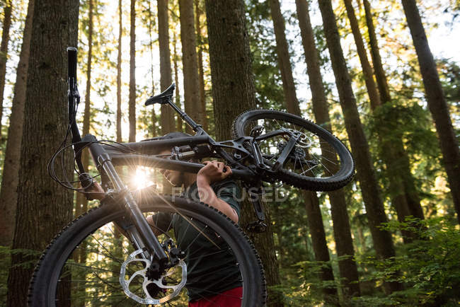 Мужчина-велосипедист с горным велосипедом во время прогулки в парке — стоковое фото