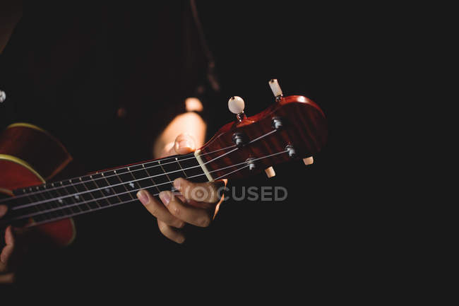 Середній розділ жінки, що грає на гітарі в музичній школі — стокове фото