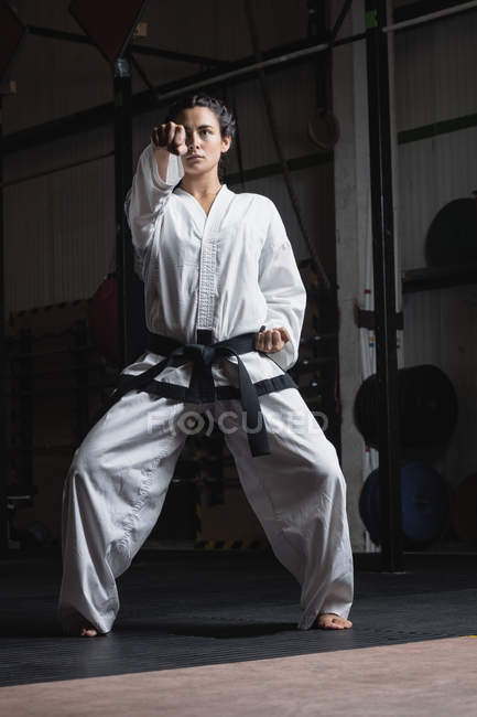 Femme pratiquant le karaté dans un studio de fitness — Photo de stock