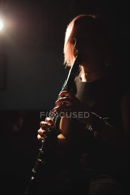 Mulher atenciosa tocando clarinete na escola de música — Fotografia de Stock