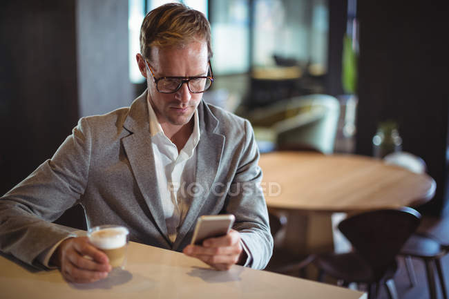 Geschäftsmann benutzt Handy beim Kaffee im Café — Stockfoto