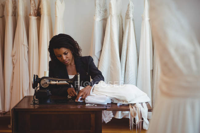 Diseñador de moda de costura en la máquina de coser en el estudio - foto de stock