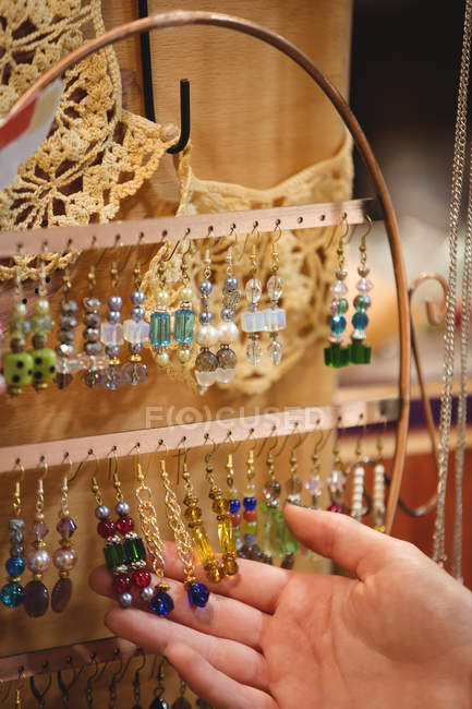 Hand of a woman holding vintage jewellery in antique shop — Stock Photo