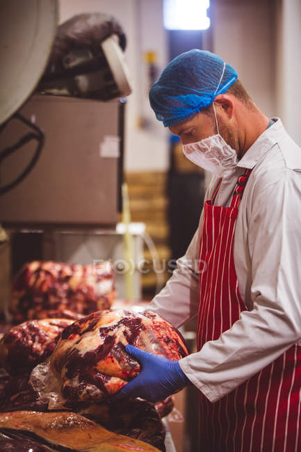 Carnicero empacando carne roja en el almacén de la carnicería - foto de stock