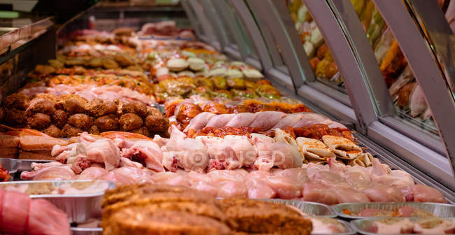 Varietà di carne marinata al banco espositore in macelleria — Foto stock