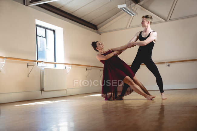 Балетные партнеры танцуют вместе в современной студии — стоковое фото
