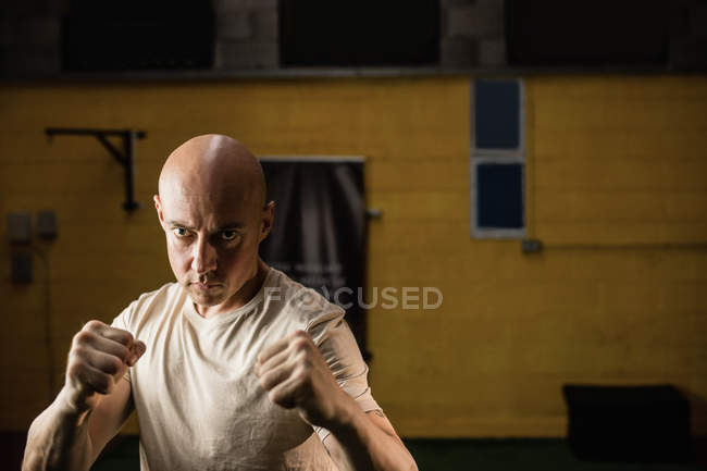 Boxer practicing boxing in fitness studio and looking at camera — Stock Photo