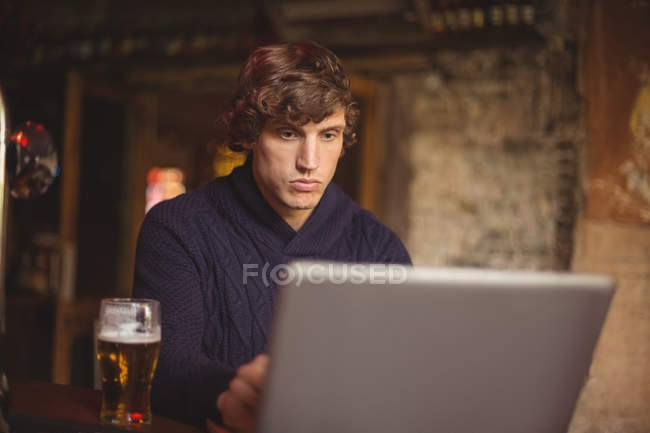 Mann benutzte Laptop an Bar — Stockfoto