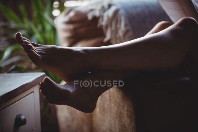 Крупним планом жіночі ноги розслабляються на дивані у вітальні вдома — стокове фото
