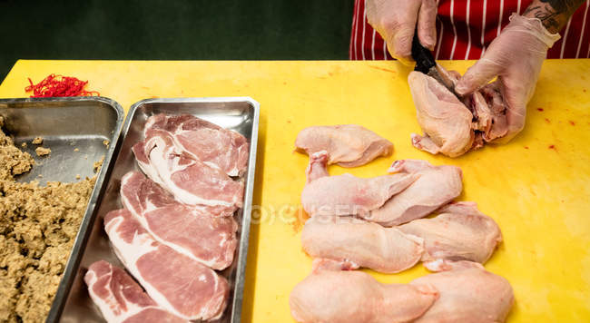 Fleischerhände hacken Hühnchen auf Arbeitstheke in Metzgerei — Stockfoto