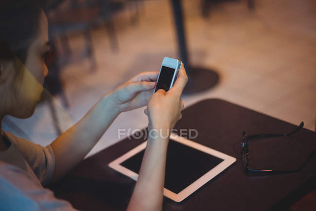 Mulher mensagens de texto no celular no café — Fotografia de Stock