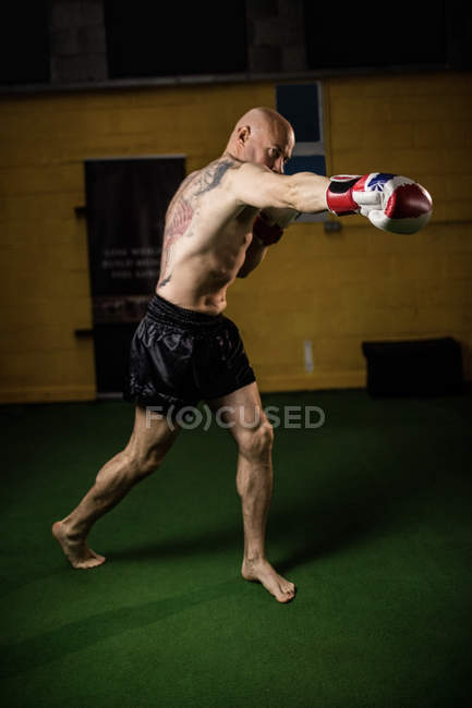 Без сорочки татуйований тайський боксер практикує в спортзалі — стокове фото