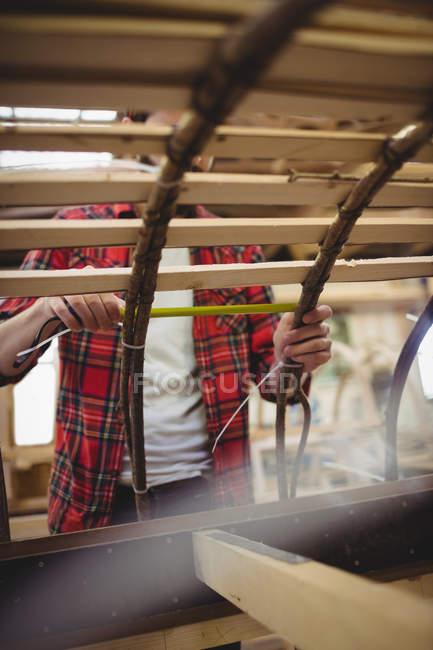 Man preparing a wooden boat frame at boatyard — Stock Photo