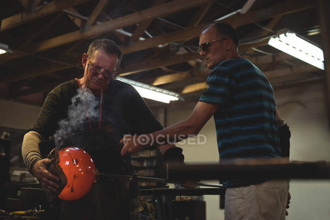 Team di soffiatori di vetro che modellano vetro fuso presso la fabbrica di soffiaggio del vetro — Foto stock
