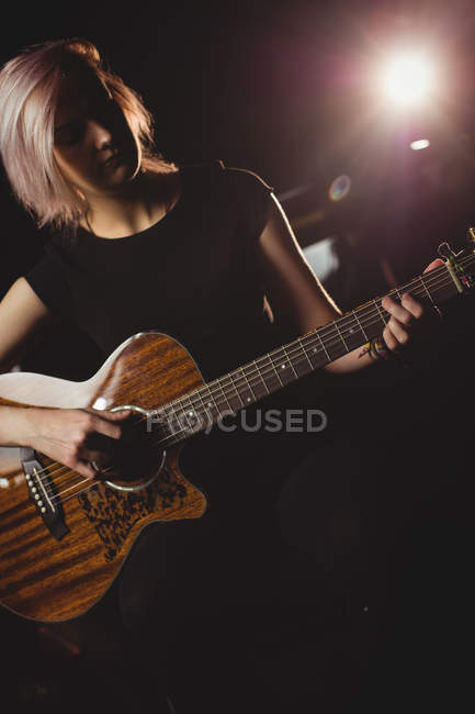 Estudante feminina tocando guitarra em um estúdio — Fotografia de Stock