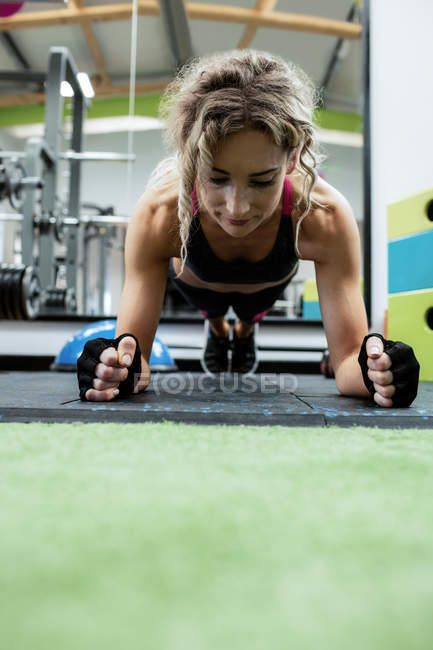 Mulher realizando exercício push-up no ginásio — Fotografia de Stock