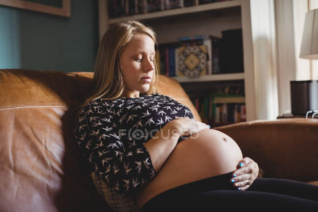 Беременная женщина отдыхает в гостиной на дому — стоковое фото