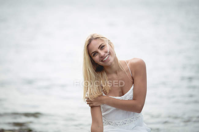 Ritratto di donna sorridente in piedi vicino al fiume — Foto stock