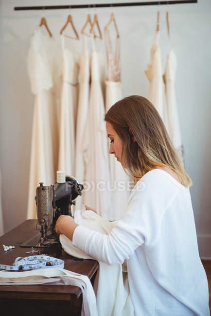 Femme couturière couture sur la machine à coudre en studio — Photo de stock