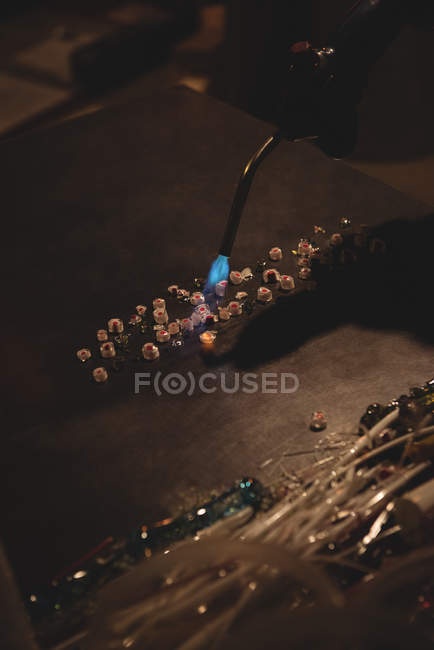 Pièces de verre en vrac chauffées sur la table de marver à l'usine de soufflage de verre — Photo de stock