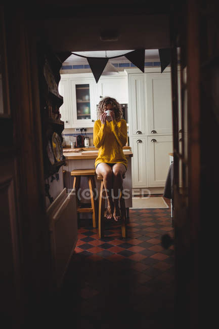 Femme buvant du café dans la cuisine à la maison — Photo de stock