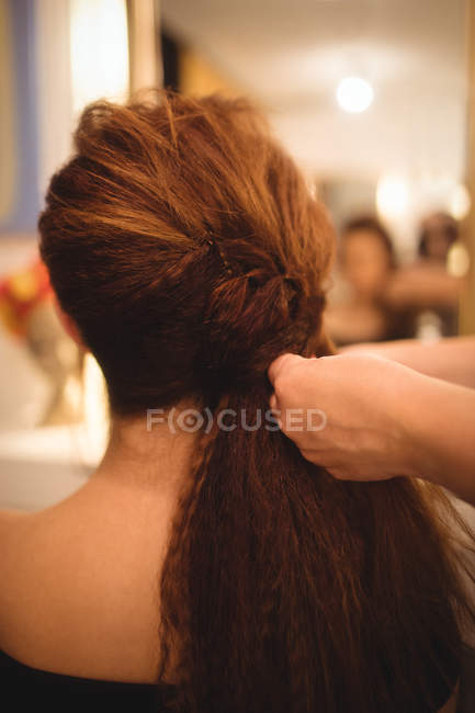 Вид ззаду жінки, що стилізує волосся в салоні — стокове фото
