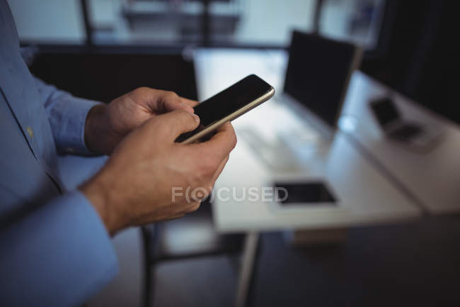 Mid section of businessman using mobile phone in office — Stock Photo