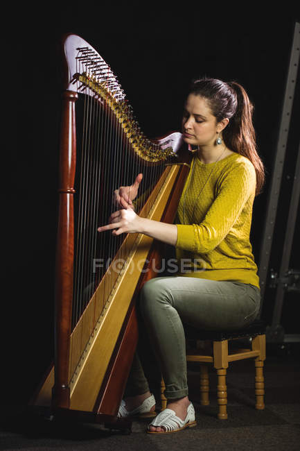 Увага жінка грає на арфі в музичній школі — стокове фото