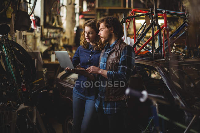 Mechanics using laptop in workshop — Stock Photo