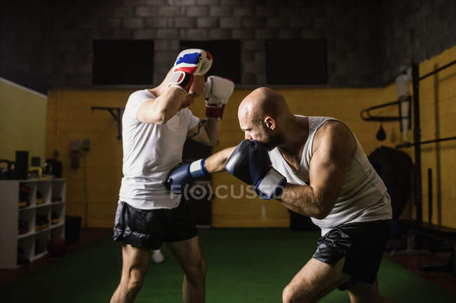 Two caucasian thai boxers practicing boxing in gym — Stock Photo