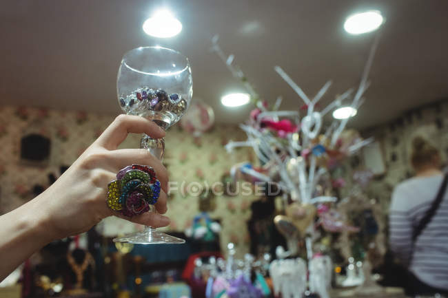 Female hand holding cup with jewelry in antique jeweler shop — Stock Photo