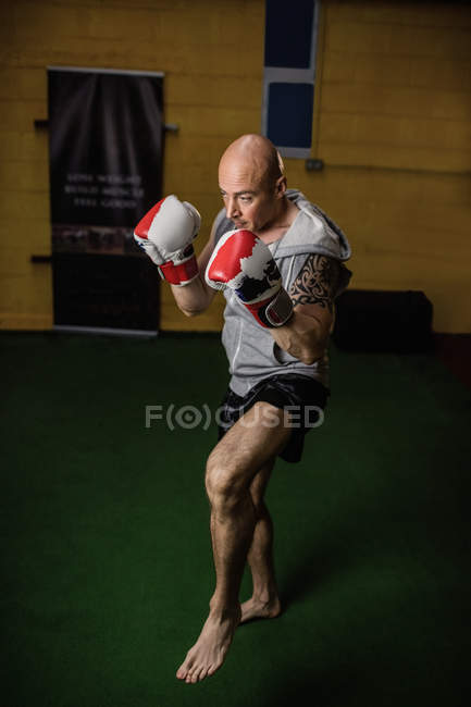 High angle view of handsome Thai boxer practicing boxing in gym — Stock Photo