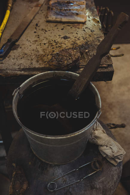 Close-up of glassblowing block in bucket at glassblowing factory — Stock Photo
